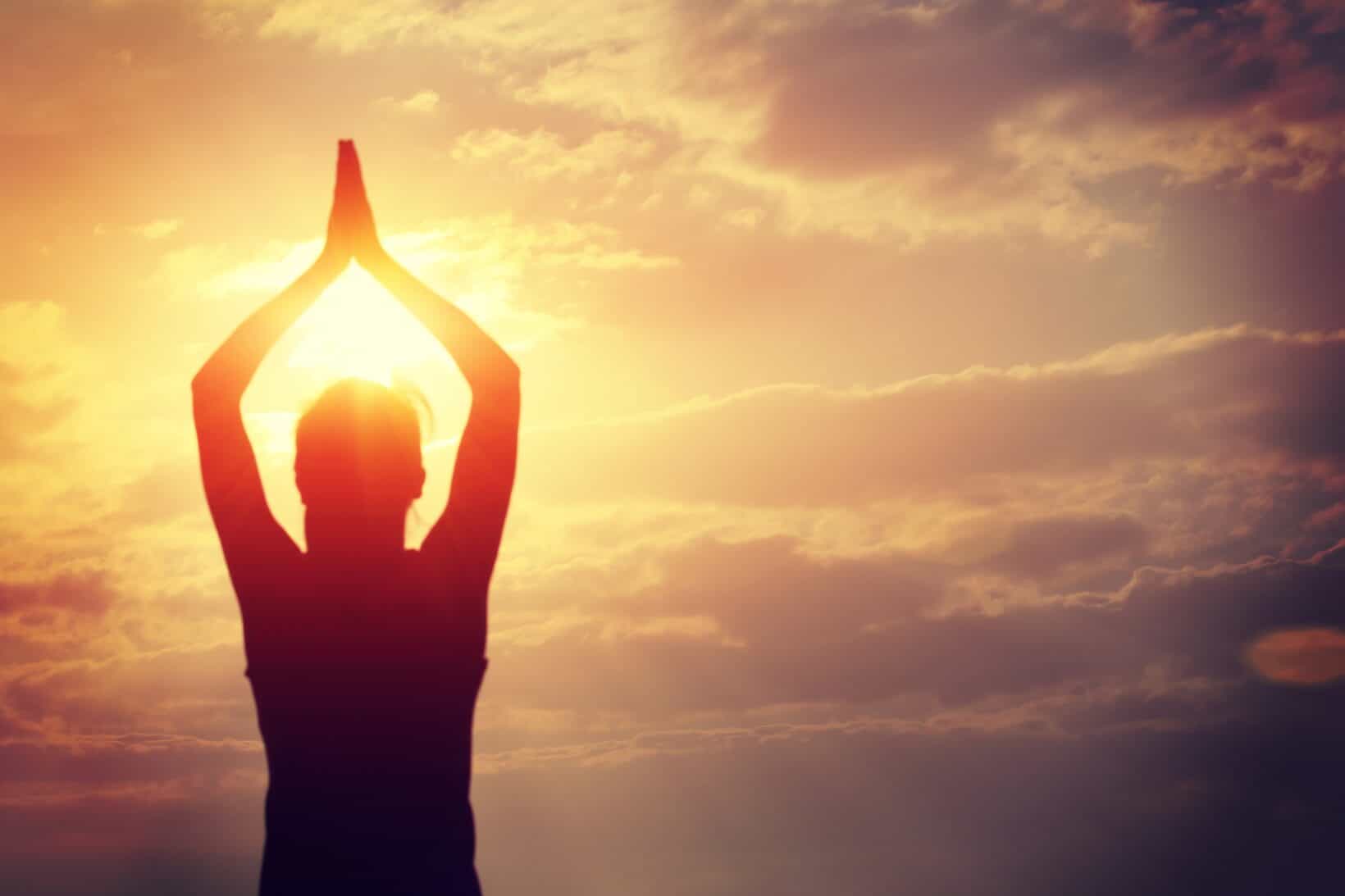 Woman doing yoga at sunrise